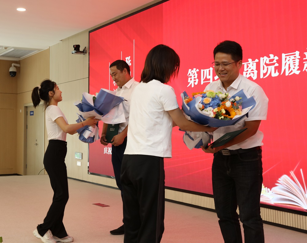 员工向离院履新教师献花(通讯员 晓萱 摄)
